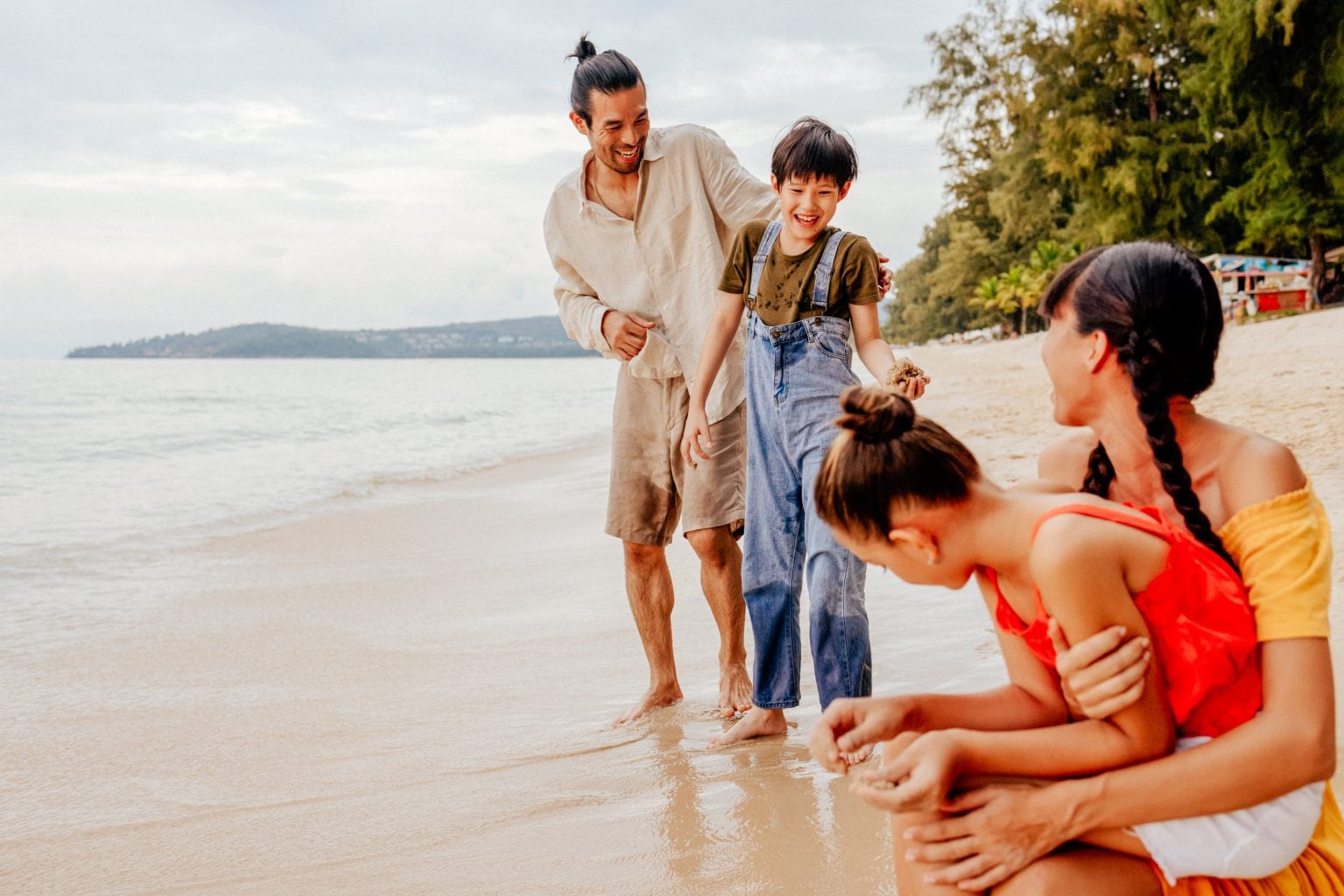 A family at the beach, enjoying quality time together in Phuket at a family photo shoot in Thailand